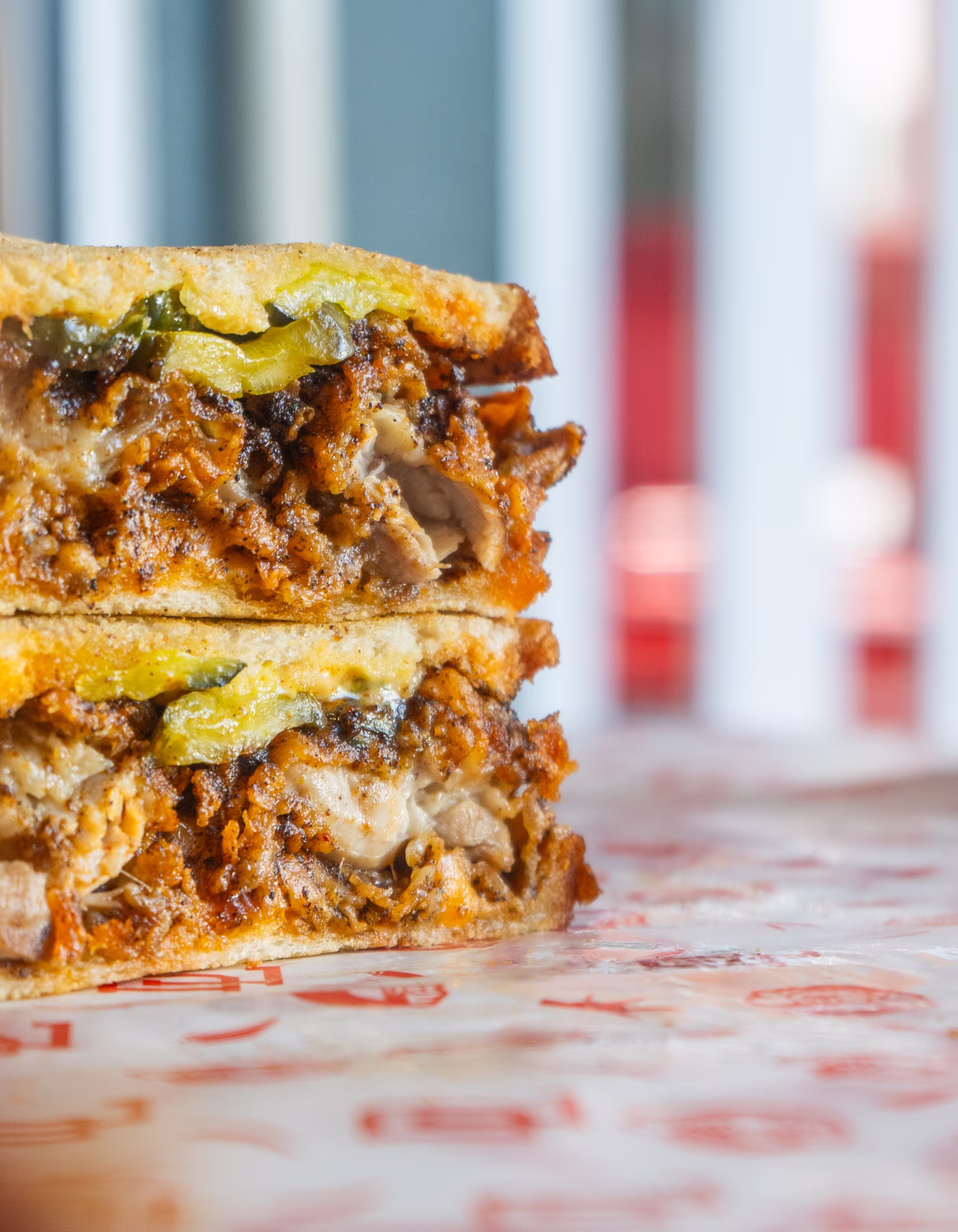 A fried chicken sandwhich with carmelized onions and cheese dust